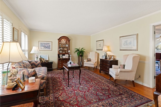 living room featuring hardwood / wood-style flooring, ornamental molding, and a textured ceiling