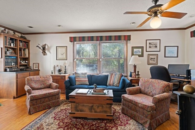 living room with ornamental molding, ceiling fan, a textured ceiling, and light hardwood / wood-style floors