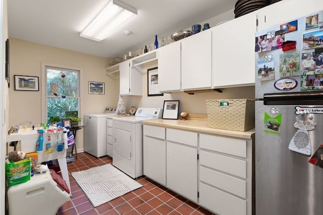 washroom with washer and clothes dryer and dark tile patterned floors