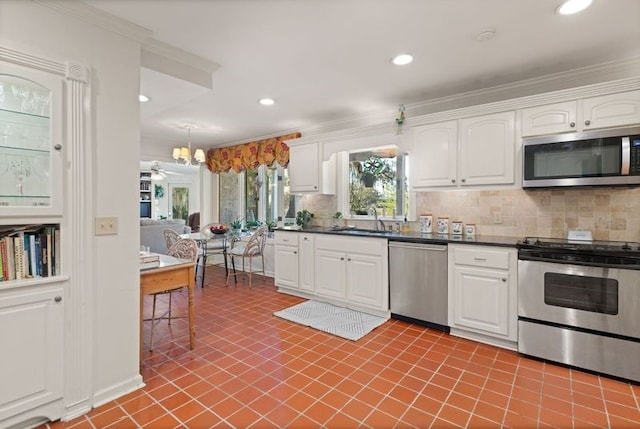 kitchen with stainless steel appliances, sink, white cabinets, and backsplash