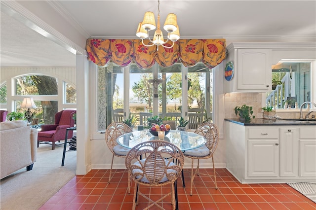 carpeted dining space with an inviting chandelier, ornamental molding, and sink