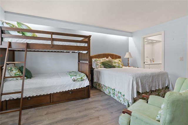 bedroom with ensuite bathroom and wood finished floors