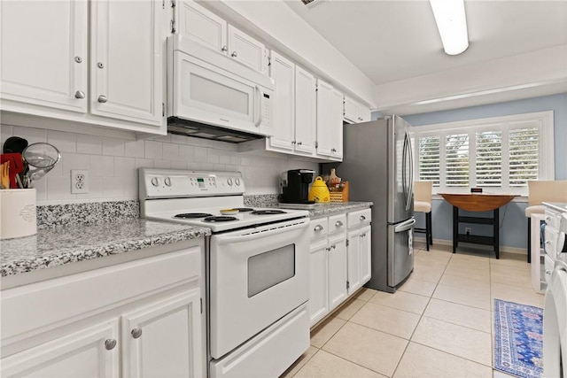 kitchen with light tile patterned floors, decorative backsplash, white appliances, and white cabinetry