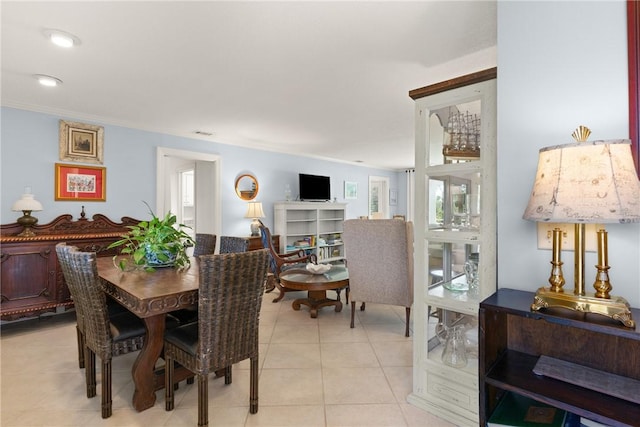 dining space featuring light tile patterned floors and ornamental molding