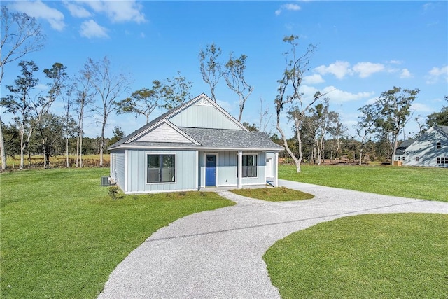 modern farmhouse with board and batten siding, a front lawn, roof with shingles, and driveway