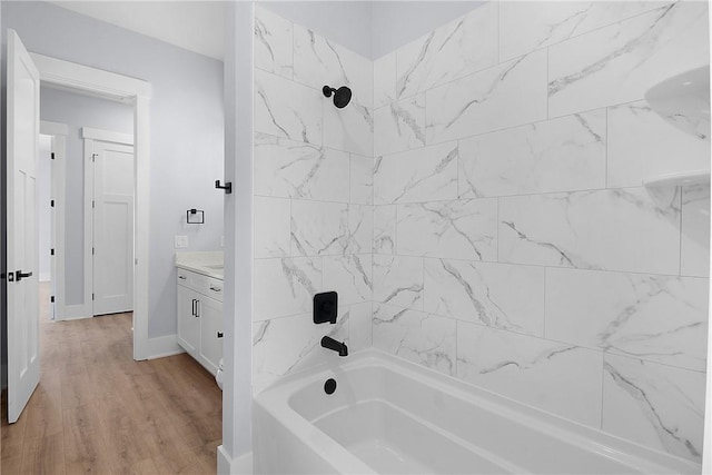 full bath with vanity, wood finished floors, tub / shower combination, and baseboards