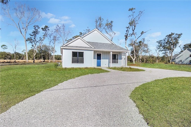 modern inspired farmhouse featuring covered porch, driveway, and a front lawn