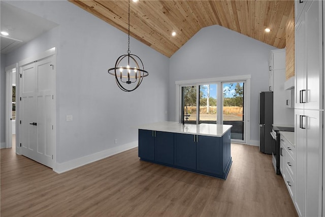 kitchen with light wood-type flooring, wooden ceiling, freestanding refrigerator, and light countertops