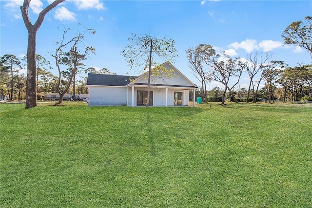 rear view of property featuring a yard