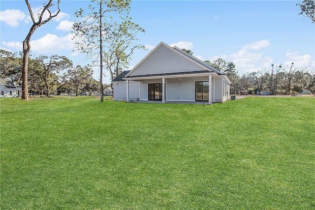 rear view of house featuring a yard