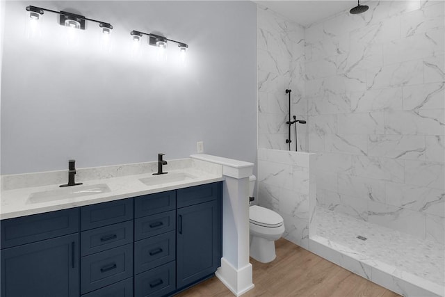 bathroom with a sink, a marble finish shower, and toilet