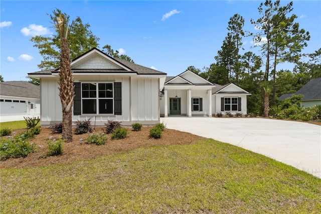 154 Ossabaw Way, Waverly, GA 31565 - view of front of house with board and batten siding, a front lawn, and driveway