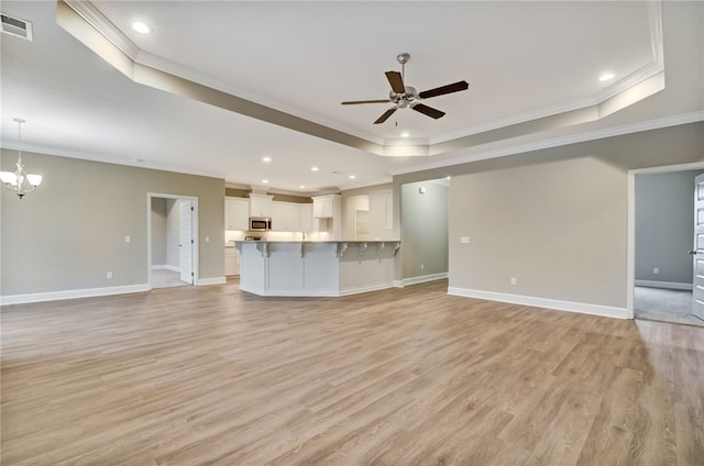 154 Ossabaw Way, Waverly, GA 31565 - unfurnished living room with a tray ceiling, ornamental molding, ceiling fan, light wood-style floors, and recessed lighting