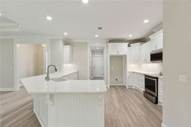 154 Ossabaw Way, Waverly, GA 31565 - kitchen with stainless steel appliances, a peninsula, crown molding, light wood finished floors, and white cabinetry