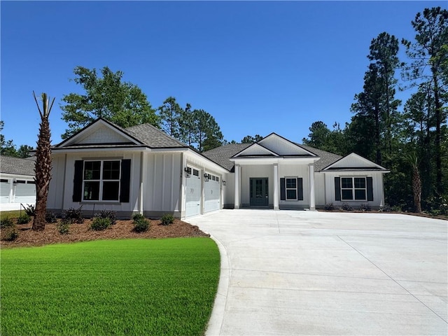 154 Ossabaw Way, Waverly, GA 31565 - ranch-style house featuring concrete driveway, an attached garage, a front yard, and board and batten siding
