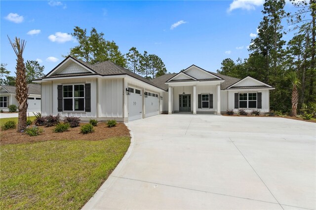 154 Ossabaw Way, Waverly, GA 31565 - view of front of property featuring board and batten siding, an attached garage, driveway, and a front yard