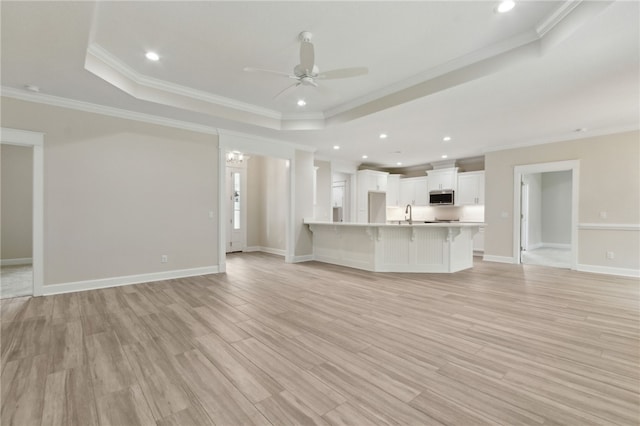 154 Ossabaw Way, Waverly, GA 31565 - unfurnished living room with a raised ceiling, ceiling fan, ornamental molding, light wood-style floors, and recessed lighting