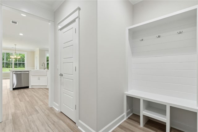 154 Ossabaw Way, Waverly, GA 31565 - mudroom featuring a chandelier, light wood finished floors, and crown molding