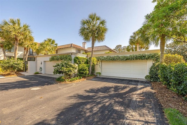 1212 River Club Dr, Sea Island, GA 31561 - mediterranean / spanish home featuring stucco siding, a tiled roof, a garage, and a chimney