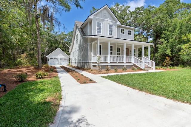 view of front facade with an outbuilding, a porch, a garage, and a front lawn