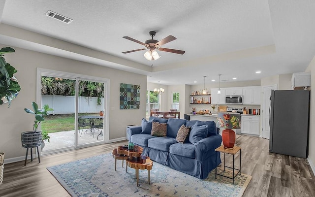 352 Pecan Pointe Dr, Brunswick, GA 31525 - living room featuring light wood-style floors, a ceiling fan, a chandelier, recessed lighting, and a textured ceiling