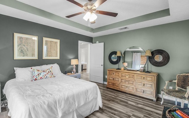 352 Pecan Pointe Dr, Brunswick, GA 31525 - bedroom with a raised ceiling, wood finished floors, and ceiling fan