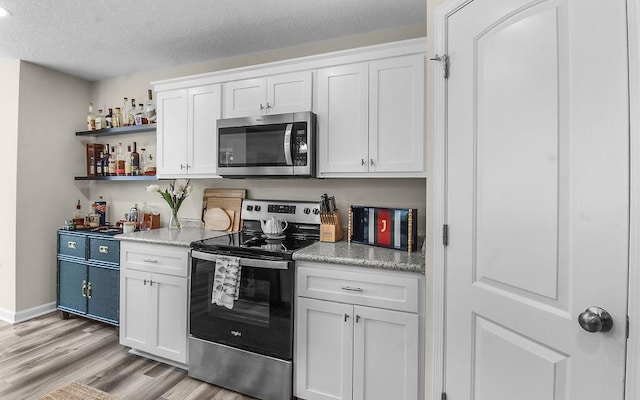 352 Pecan Pointe Dr, Brunswick, GA 31525 - kitchen with appliances with stainless steel finishes, light wood-style flooring, white cabinetry, light countertops, and a textured ceiling