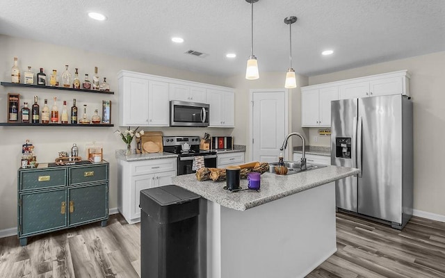 352 Pecan Pointe Dr, Brunswick, GA 31525 - kitchen featuring appliances with stainless steel finishes, light wood-type flooring, white cabinetry, recessed lighting, and a textured ceiling