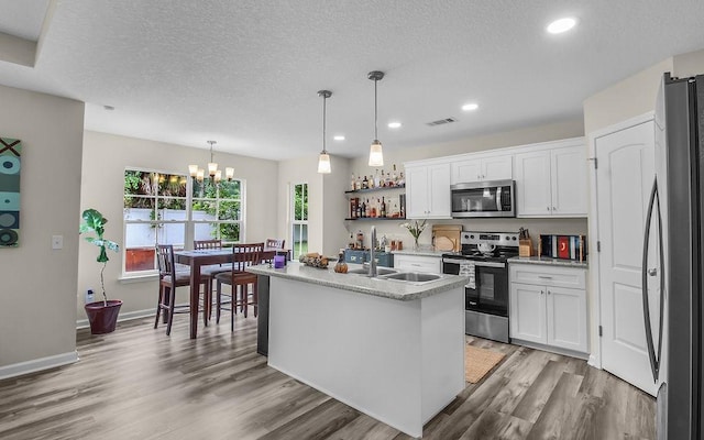 352 Pecan Pointe Dr, Brunswick, GA 31525 - kitchen featuring appliances with stainless steel finishes, a chandelier, white cabinets, light countertops, and light wood-style flooring