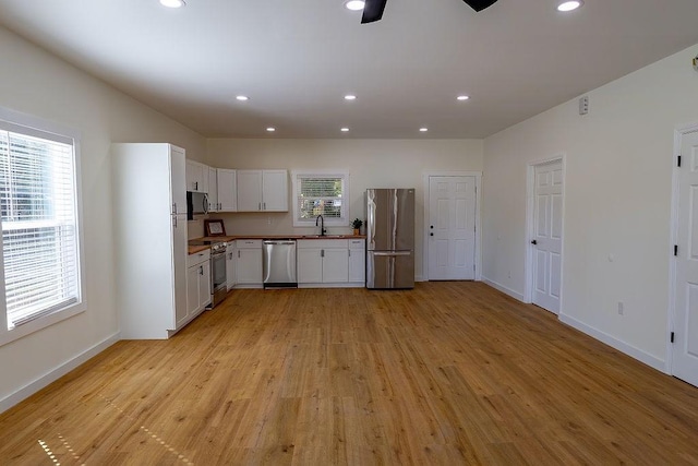 kitchen with a sink, a wealth of natural light, recessed lighting, and appliances with stainless steel finishes