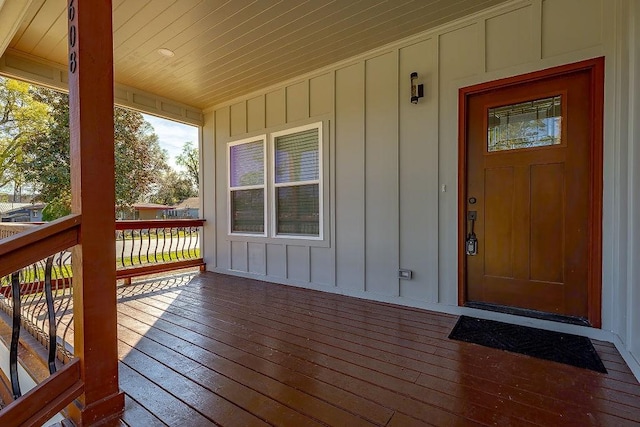 view of exterior entry featuring covered porch and board and batten siding