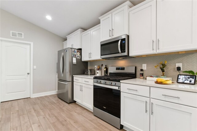 316 Chinquapin Dr, Saint Marys, GA 31558 - kitchen with appliances with stainless steel finishes, backsplash, vaulted ceiling, light countertops, and white cabinets