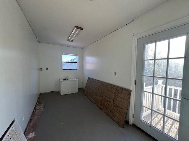 hall featuring a healthy amount of sunlight and concrete floors