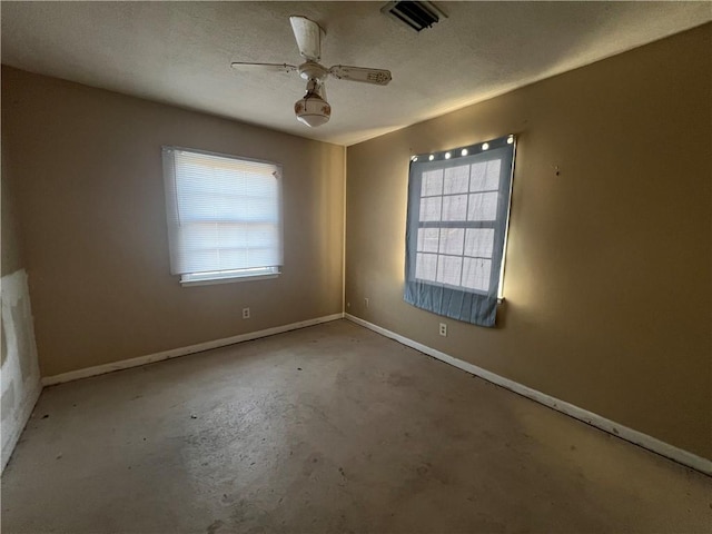 empty room with ceiling fan, a textured ceiling, and concrete floors