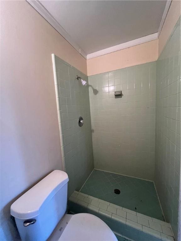 bathroom featuring toilet and a tile shower