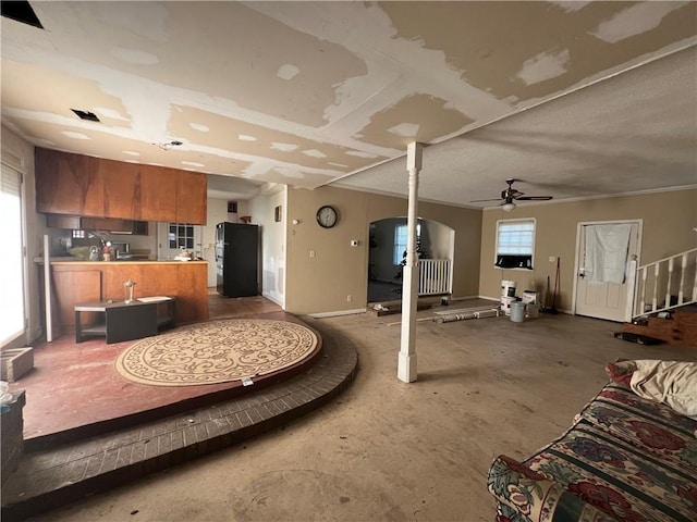 living room with ceiling fan and concrete flooring