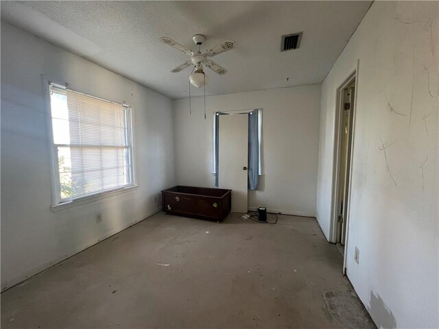 unfurnished bedroom featuring a textured ceiling and ceiling fan