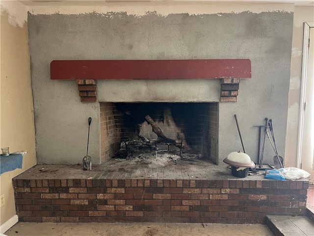 interior details with concrete floors and a brick fireplace