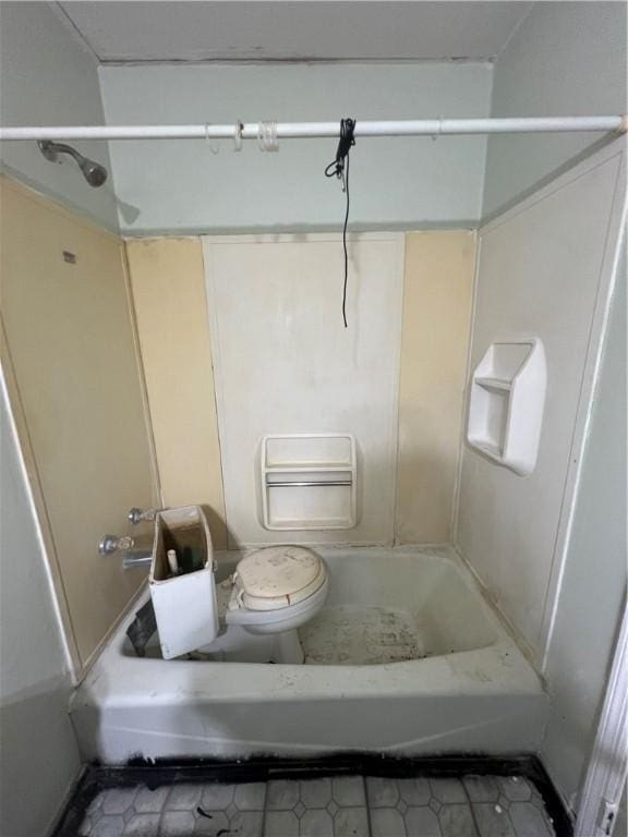 bathroom featuring tile patterned flooring, toilet, and a bathtub