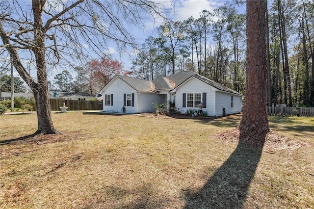 ranch-style house featuring a front yard and fence