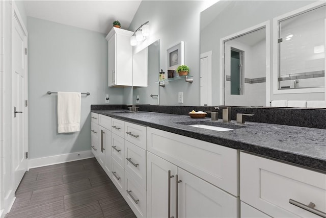 636 Old Plantation Rd, Jekyll Island, GA 31527 - full bathroom featuring baseboards, double vanity, tiled shower, and wood finished floors