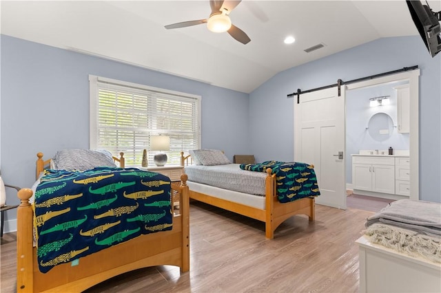 636 Old Plantation Rd, Jekyll Island, GA 31527 - bedroom with lofted ceiling, a barn door, light wood-style flooring, and ensuite bathroom