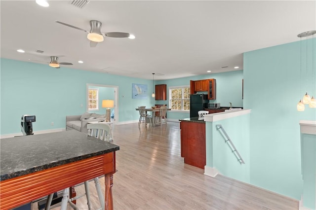 636 Old Plantation Rd, Jekyll Island, GA 31527 - kitchen with freestanding refrigerator, light wood-style floors, recessed lighting, hanging light fixtures, and stainless steel microwave