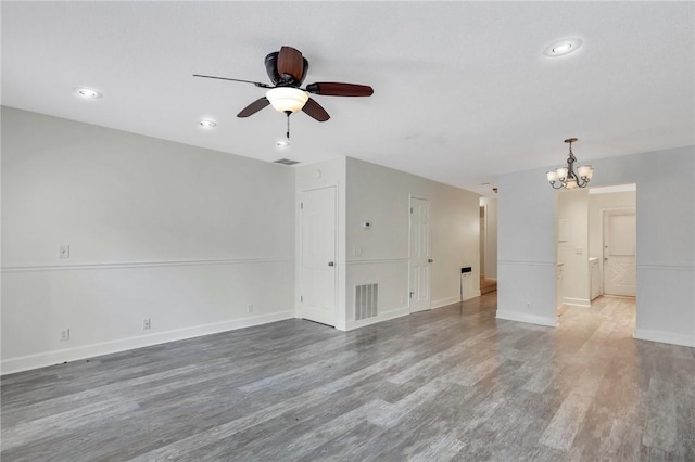 unfurnished living room with hardwood / wood-style floors and ceiling fan with notable chandelier