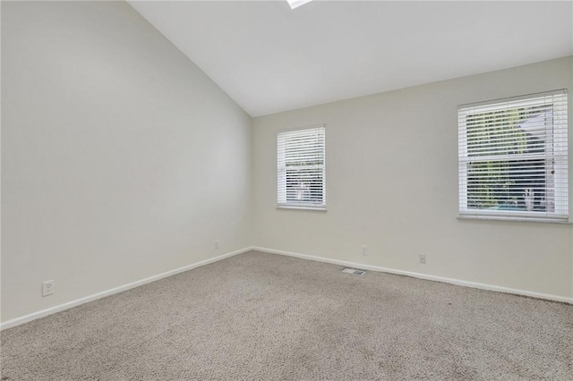 carpeted empty room with lofted ceiling