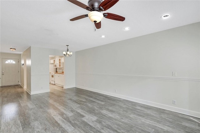 unfurnished living room featuring hardwood / wood-style floors and ceiling fan with notable chandelier