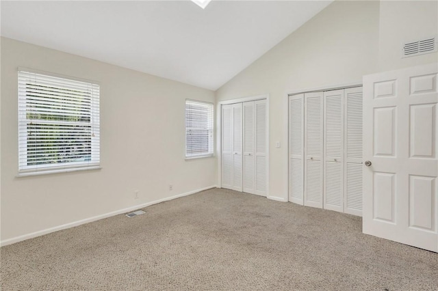 unfurnished bedroom with carpet floors, multiple windows, and multiple closets