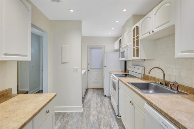 kitchen featuring light wood-type flooring, white appliances, white cabinetry, and sink