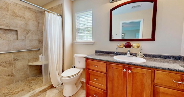 2300 Albany Ave, Waycross, GA 31503 - bathroom featuring vanity, toilet, a tile shower, and tile patterned flooring