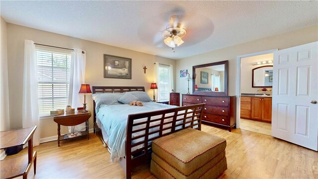 2300 Albany Ave, Waycross, GA 31503 - bedroom featuring multiple windows, light wood-type flooring, a textured ceiling, ensuite bath, and ceiling fan